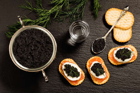 Black caviar served on crackers with vodka and additivesの写真素材