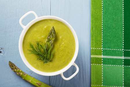 Delicious soup with asparagus, served in white bowls.の写真素材