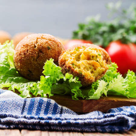 Chickpea falafel balls on a wooden desk with vegetablesの写真素材