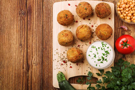 Chickpea falafel balls on a wooden desk with vegetablesの写真素材