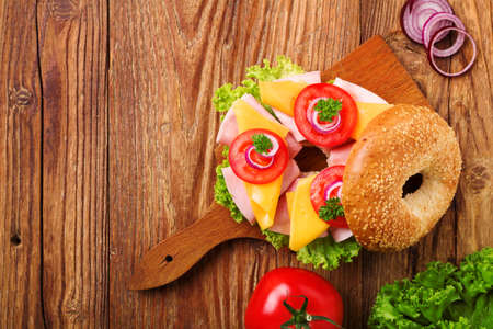 Healthy sandwich on a bagel with ham, cheese and vegetables. Top view.の写真素材