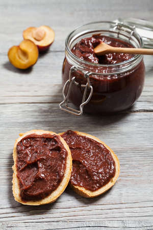 Homemade plum jam on wooden boardの写真素材
