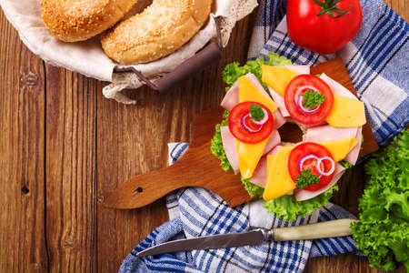 Healthy sandwich on a bagel with ham, cheese and vegetables. Top view.の写真素材