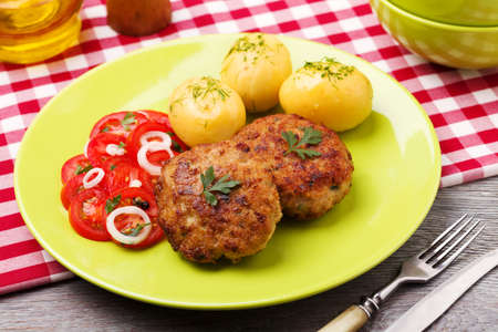 Fresh, homemade meatballs, served with tomato salad and new potatoes.の写真素材