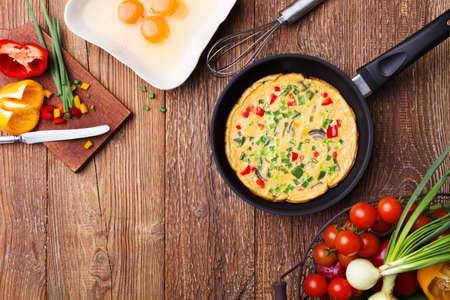 Delicious omelette with vegetables in a pan.