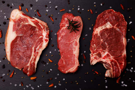Fresh, raw beef steak on a black stone trayの写真素材