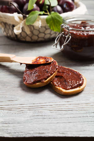 Homemade plum jam on wooden board