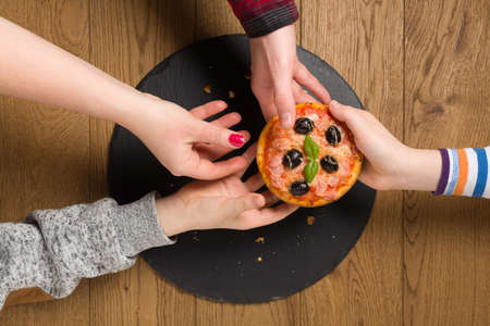 The family treats a mini pizza.の写真素材