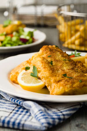 Fried cod with french fries on white plaet.の写真素材
