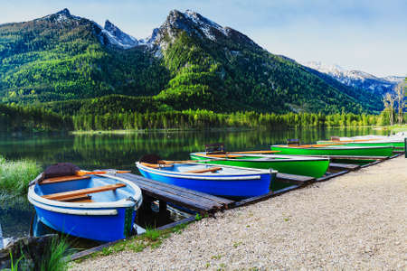 Moored boats on the lake with snowy alpine peak in the background.の写真素材