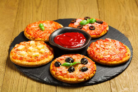 Mix of mini pizzas on a stone tryの写真素材