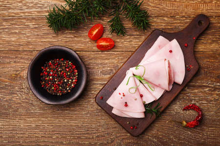 Delicious cooked ham on a wooden board with spices.の写真素材
