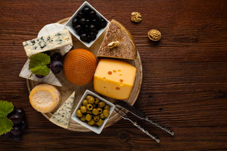 Mix cheese on wooden board with grapes. Top view.の写真素材