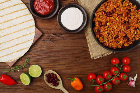 Burritos wraps with meat, beans and vegetables on wooden boardの写真素材