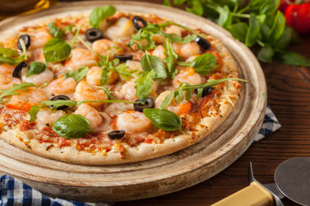 Pizza with shrimps. Front view. Wooden board background.の写真素材