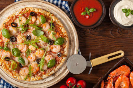 Pizza with shrimps. Top view. Wooden board background.の写真素材