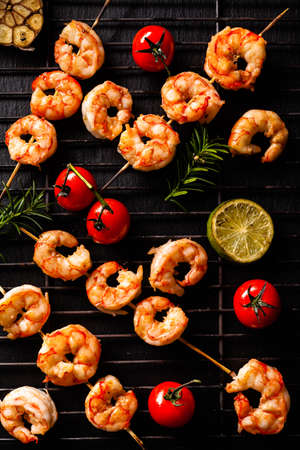 Grilled shrimp skewers. Top view. Black background.の写真素材