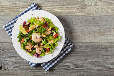 Shrimp salad with tomato, olives and cashew nuts. Top viewの写真素材