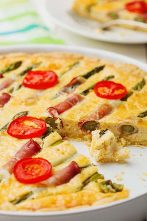 Tart with asparagus and tomatoes on white wooden background.の写真素材