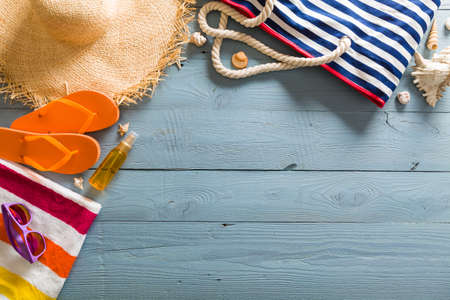 Summer vacation background theme with seashells, bag, hat, sunglasses and blue wood background with...