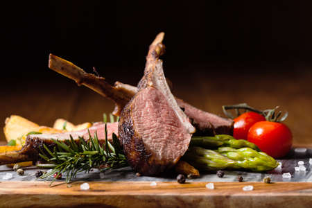 Baked lamb loin, served with asparagus. Dark background.の写真素材
