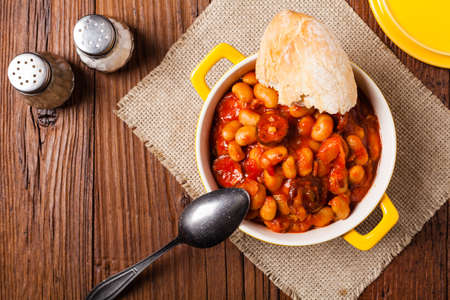 Baked beans in tomato sauce served in yellow, clay bowls. Top view.の写真素材