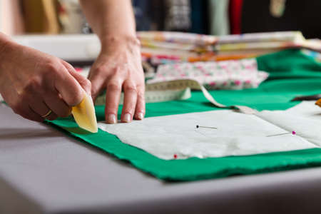 Sewing workshop. Preparing the sewing blanket. Drawing on the material. The tailor draws a pattern...