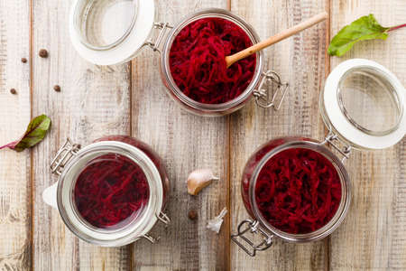 Grated beetroot marinated in jars. Wooden background. Top view.の写真素材