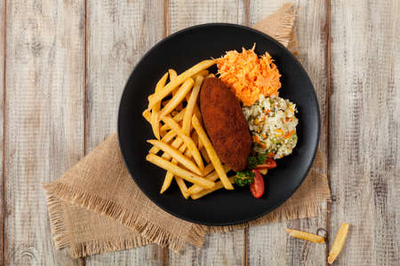 Chicken Kiev (de Volaille chop) with french fries and salads. Top view.の写真素材