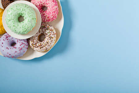 Colorful donuts on a blue background. Top viewの写真素材