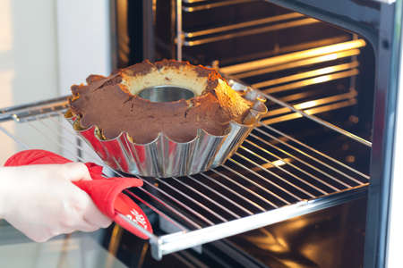 Baking cake. Next stage, remove the baked cake from the oven.の写真素材