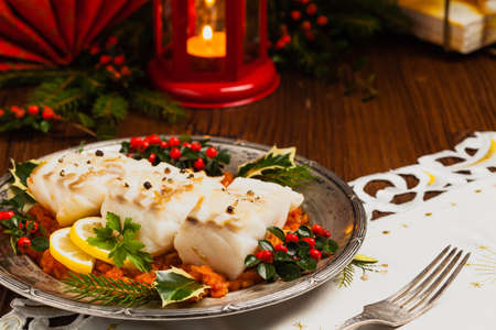Christmas fish. Roasted cod pieces, served in vegetable sauce. Xmas styling. Front view.の写真素材