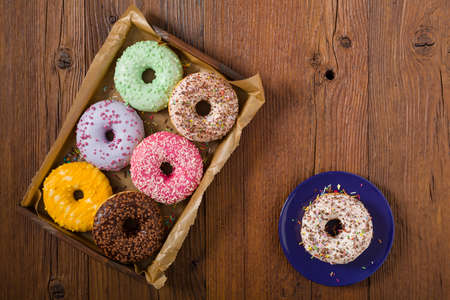 Colorful donuts on a wooden background. Top viewの写真素材