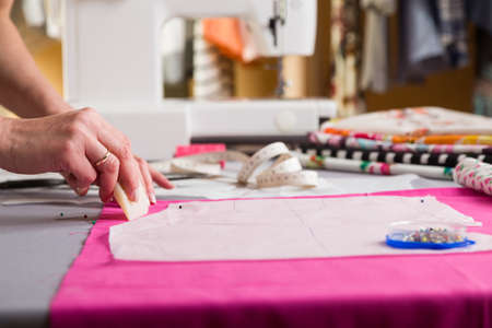 Sewing workshop. Preparing the sewing blanket. Drawing on the material. The tailor draws a pattern to cut.の写真素材