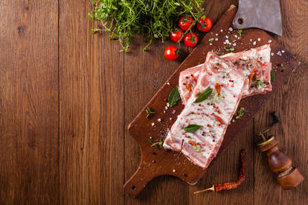 Raw pork ribs, on a plate sprinkled with spices. Top view.の写真素材