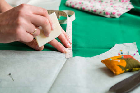 Sewing workshop. Preparing the sewing blanket. Drawing on the material. The tailor draws a pattern to cut.の写真素材