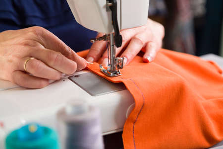 Sewing workshop. Stapling the material on the machine.