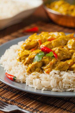 Chicken Curry Sauce. Served with rice. Front view. Natural wooden background.の写真素材