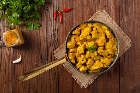 Chicken Curry Sauce. Served in a pan. Top view. Natural wooden background.の写真素材