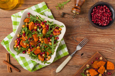 Sweet potato salad with lentils, pomegranates and rocket. Top view. Natural wooden background.の写真素材