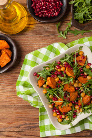 Sweet potato salad with lentils, pomegranates and rocket. Top view. Natural wooden background.の写真素材
