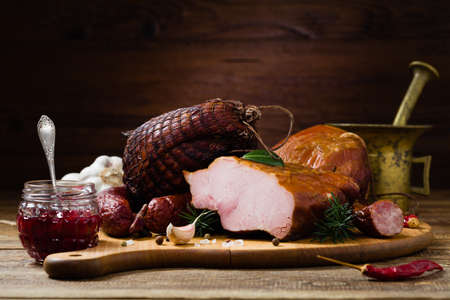 Smoked pork on wooden board. Different types of meat.の写真素材