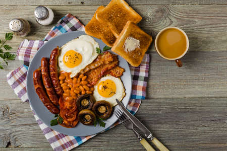 Full English breakfast, with sausage, mushrooms, beans and a fried egg. Top view. の写真素材