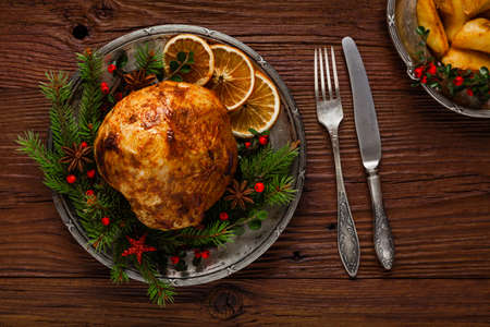 Christmas baked ham, served on the old plate. Spruce twigs all around. Top view.の写真素材