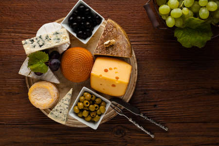 Mix cheese on wooden board with grapes. Top view.の写真素材