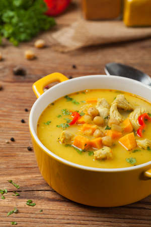 Sweet potato soup with chicken and lentils. Front view. Natural wooden background.の写真素材