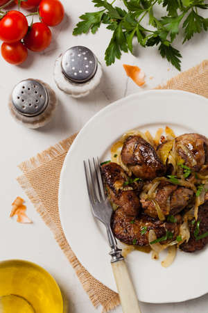 Fried chicken liver with onions. Top view. Stone background.の写真素材