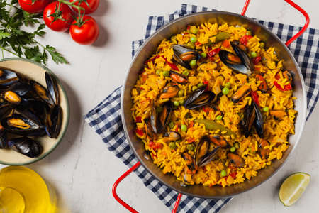 Traditional paella with mussels. Top view. Stone white background.の写真素材