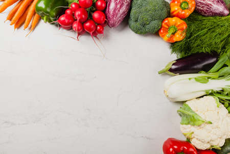 Stone background with a border of fresh vegetables.  Top view.の写真素材