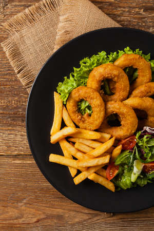 Roasted squid rings with fries. Top viewの写真素材